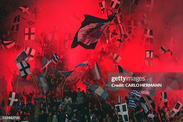 Napoli's fans light flares during the Italian Serie A football match SSC Napoli vs Bologna FC on April 19, 2016 at the San Paolo stadium in Naples. /...