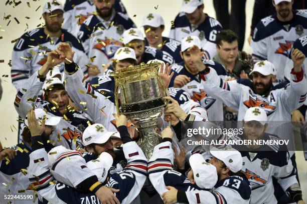 Metallurg Magnitogorsk team members celebrate as they hold the trophy of the Kontinental Hockey League after winning the final match against CSKA...