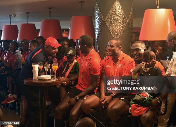 Kenya rugby 7's team, Shujaa's Collins Injera, Willy Ambaka and Humphrey Kayange sit with some of their teammates during a press conference at the...