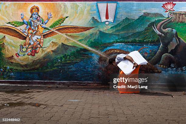 Hindu pilgrim praying at Sri Venkateswara swami temple in Tirumala, Andhra Pradesh, India. The pilgrim seems to be blessed by a ray of light from the...