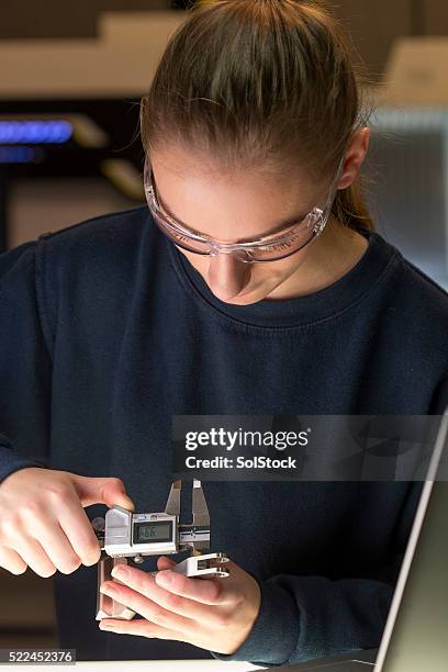 donna utilizzando un dispositivo precisione di misura - industrial laborer foto e immagini stock