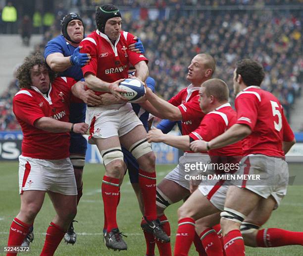Welsh number eight Michael Owen catches the ball as French lock Jerome Thion tries to hold him despite defense of Wales players, prop Adam Jones ,...