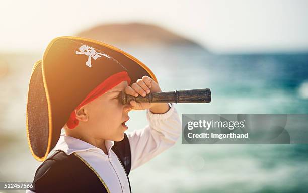 pequeño pirata mirando con spyglass - catalejo fotografías e imágenes de stock