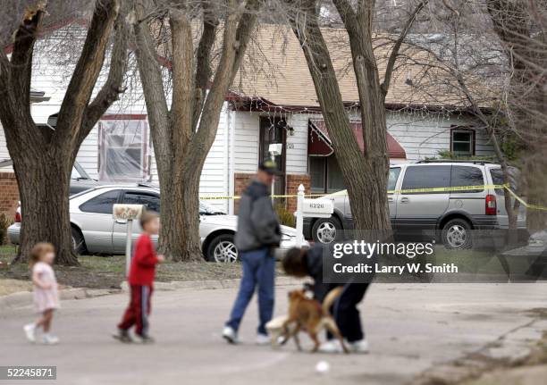 Family walks in the street in front of the house that Dennis Rader lives in February 26, 2005 in Park City, Kansas. Rader is the suspect whom police...