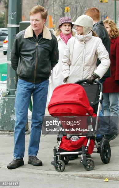 Talk show host Conan O'Brien and wife Liza Powell walk their daughter Neve along Central Park west on February 26, 2005 in New York City.