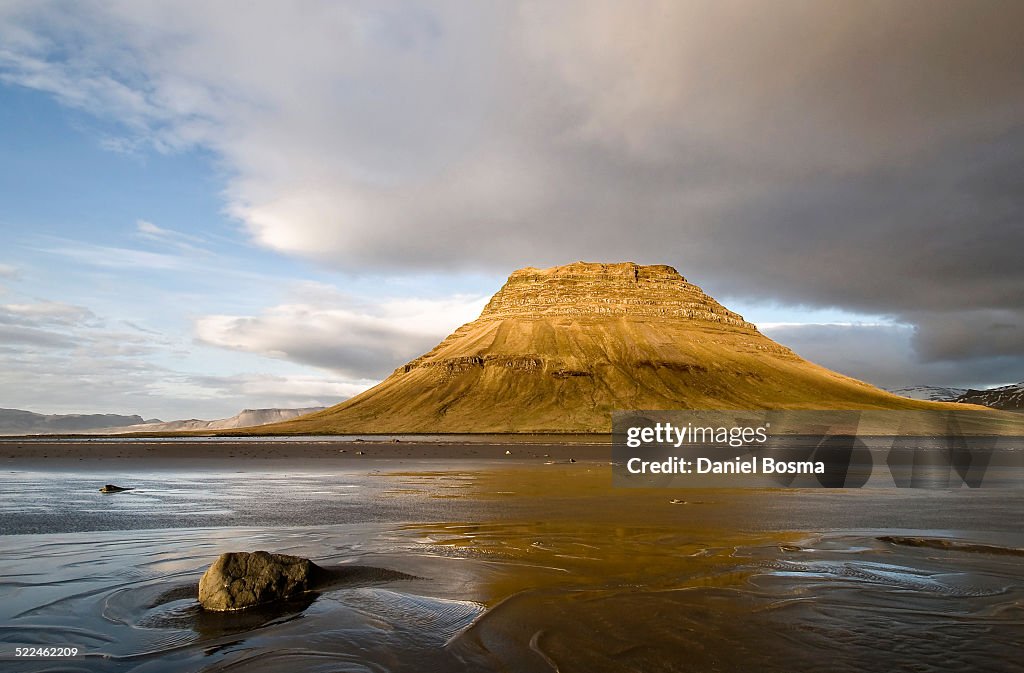 Sunny mountain reflected in tidal sands in Iceland