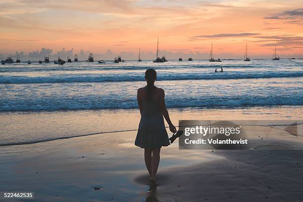 woman walking on the beach at sunset - san juan del sur stockfoto's en -beelden