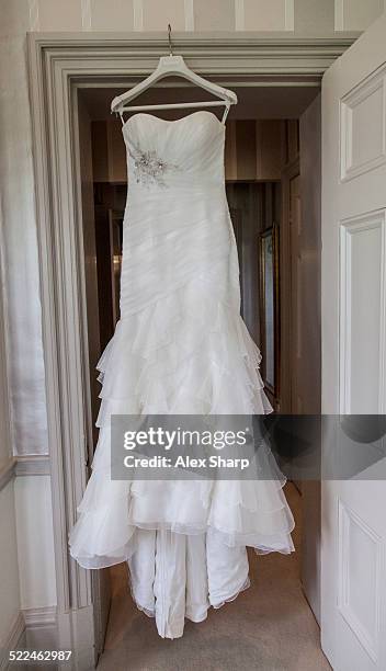 wedding dress waiting to be worn - wedding dress on hanger stock pictures, royalty-free photos & images