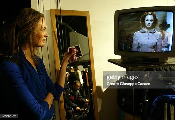 Model watches the show on a television at the end of the Philosophy By Alberta Ferretti fashion show as part of Milan Fashion Week Autumn/Winter...