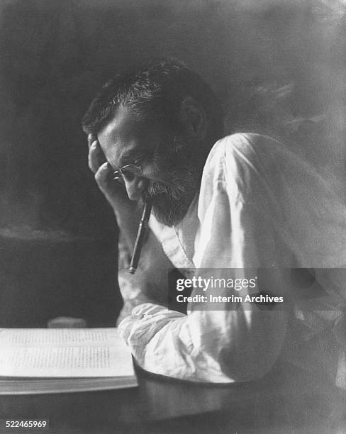 Portrait of Charles Proteus Steinmetz, engineer and mathematician, as he smokes a cigar while reading a book, circa 1915.