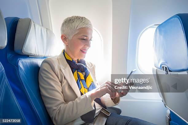 business woman at airplane - mobile on plane stock pictures, royalty-free photos & images