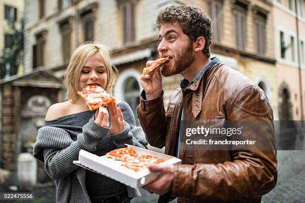 couple eating a pizza in italy - italy city break stock pictures, royalty-free photos & images