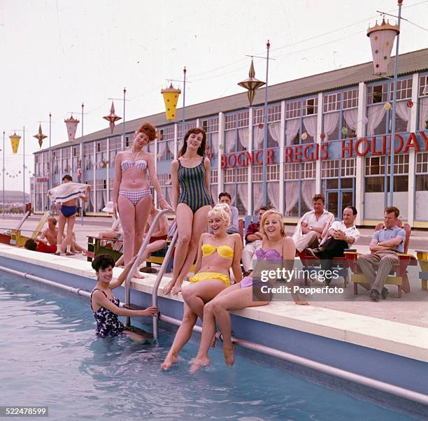Sixties Fashion - Young women wearing bikinis and swimming costumes pose beside the swimming pool at Butlins holiday resort in Bognor Regis, England...