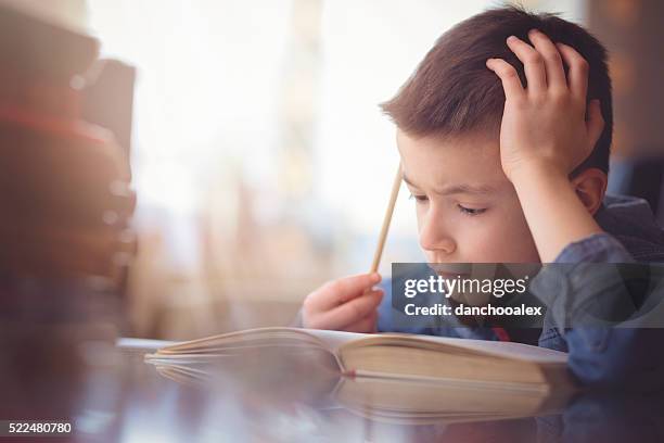 cute little boy doing his homework - dust bildbanksfoton och bilder