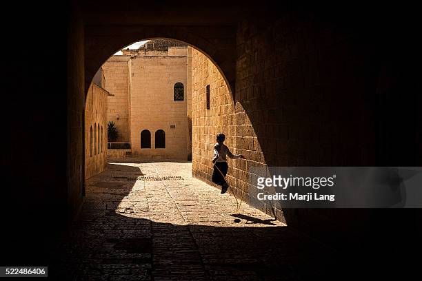 Young boy playing with a skipping rope in a street of the Jewish quarters in old Jerusalem, Israel and Palestine capital.