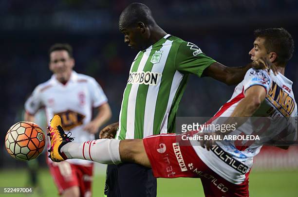 Footballer Luciano Balbi of Argentina's team Huracan vies for the ball with Victor Ibarbo of Colombia's Atletico Nacional during their Libertadores...