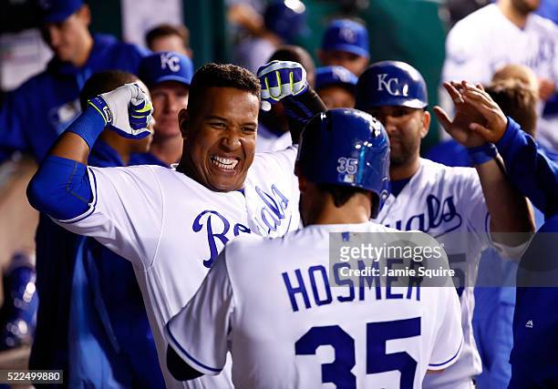 Salvador Perez of the Kansas City Royals celebrates with Eric Hosmer and Kendrys Morales in the dugout after hitting a 3-run home run during the 5th...