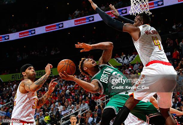 Marcus Smart of the Boston Celtics drives against Paul Millsap and Mike Scott of the Atlanta Hawks in Game Two of the Eastern Conference...