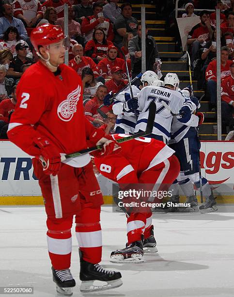 Brendan Smith of the Detroit Red Wings looks on with Justin Abdelkader as the Tampa Bay Lightning celebrate a third period goal in Game Four of the...