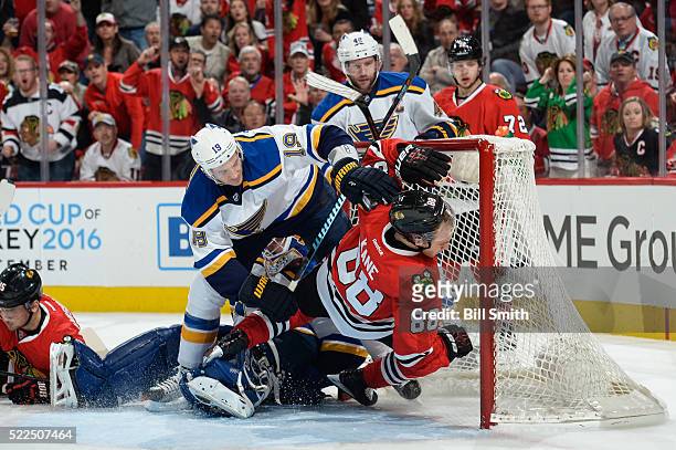 Jay Bouwmeester of the St. Louis Blues pushes Patrick Kane of the Chicago Blackhawks into the net in the first period of Game Four of the Western...