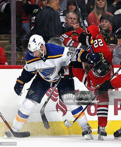 Troy Brouwer of the St. Louis Blues and Marcus Kruger of the Chicago Blackhawks battle along the boards in Game Four of the Western Conference First...