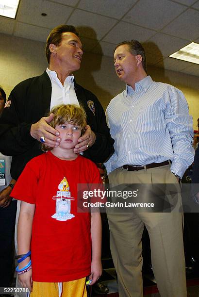 Chairman and CEO of NASCAR Brian France talks with California governor Arnold Schwarzenegger and his son Christopher during the NASCAR Nextel Cup...