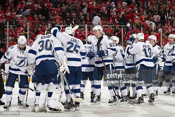 Ben Bishop and Matt Carle of the Tampa Bay Lightning celebrate a win with teammates on the ice after Game Four of the Eastern Conference First Round...