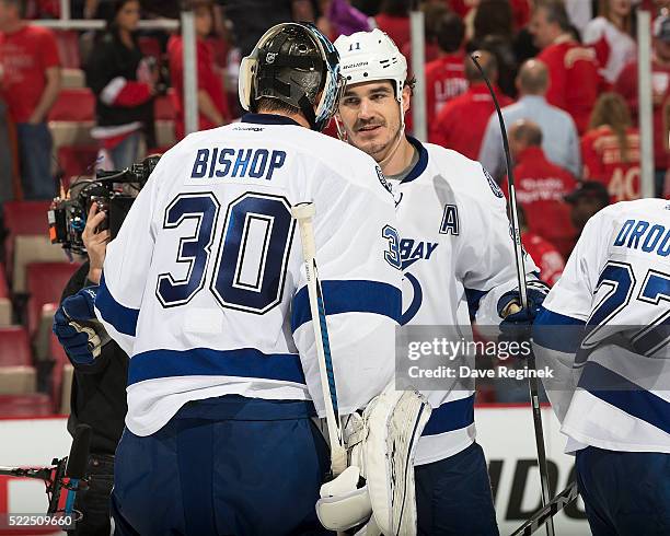 Ben Bishop and Brian Boyle of the Tampa Bay Lightning celebrate a win with teammates on the ice after Game Four of the Eastern Conference First Round...