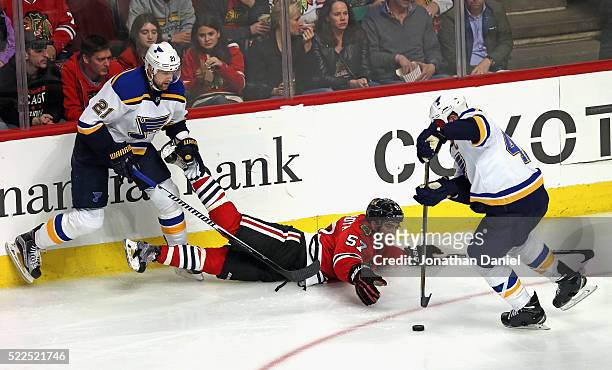 Patrik Berglund of the St. Louis Bluesdumps Trevor van Riemsdyk of the Chicago Blackhawks to the ice as David Backes controls the puck in Game Four...