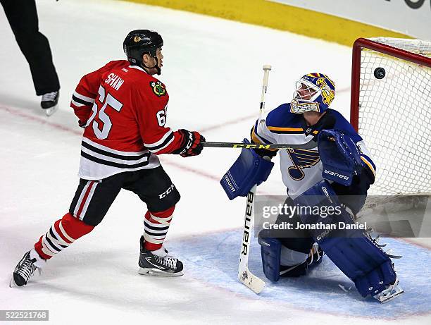 Andrew Shaw of the Chicago Blackhawks watches as the puck sails over Brian Elliott of the St. Louis Blues on a goal by Duncan Keith in the third...
