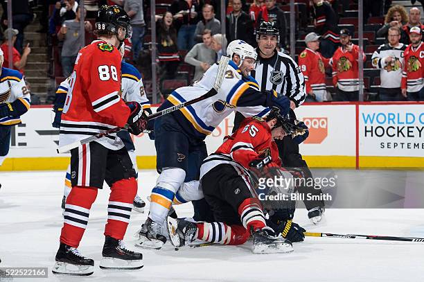 Andrew Shaw of the Chicago Blackhawks lands on Alexander Steen of the St. Louis Blues as Troy Brouwer pushes behind in the third period of Game Four...