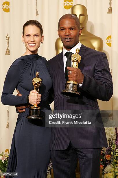 Actress Hilary Swank poses with her "Best Actress in a Leading Role" award for "Million Dollar Baby" with actor Jamie Foxx and his award for "Best...