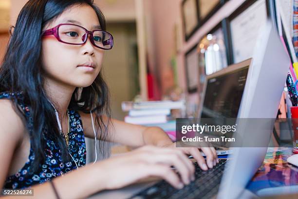 young girl sitting in front of laptop - girl looking at computer foto e immagini stock