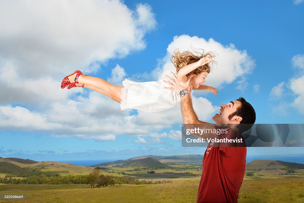 Father playing with daughter outdoors