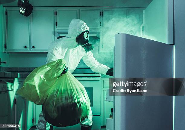 sucio refrigerador limpieza en traje de materiales peligrosos iluminando - hazmat fotografías e imágenes de stock