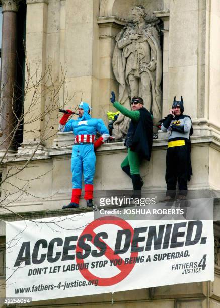 Three protesters from the campaign group Fathers 4 Justice dressed as Captain America , Robin and Batman wave from a balcony on the Foreign Office...
