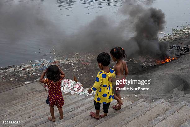 Aluminum foil papers that are rejected by the small industries are burning at the bank of river Buriganga, Dhaka, Bangladesh, causing heavy air...