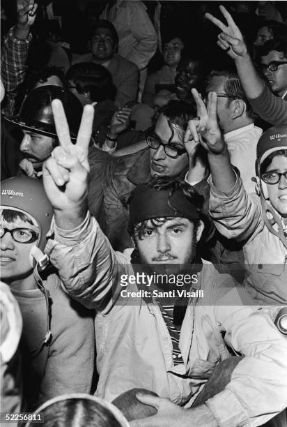 Anti-war protestors sitting down at a demonstration outside of the 1968 Democratic National Convention hold up peace signs, Chicago, Illinois, August...