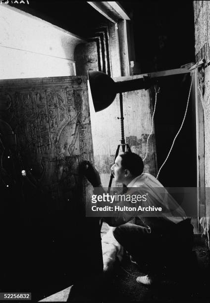 British archaeologist Howard Carter opens the doors of the second of four gold shrines surrounding the sarcophagus of Pharaoh Tutankhamun, Valley of...