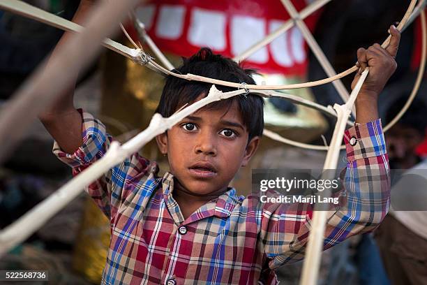Portrait of a young child helping his parents working in the making of Raavan idols for Dussehra festival in New Delhi, India.