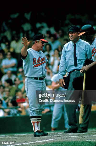 Manager Earl Weaver of the Baltimore Orioles has a discussion with the home plate umpire while Frank Robinson waits to bat during a 1969 game against...