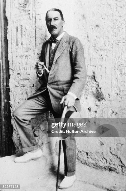 British Egyptologist Howard Carter stands with one foot up on a step at the entrance to an Egyptian archaeological site, Egypt, 1923.