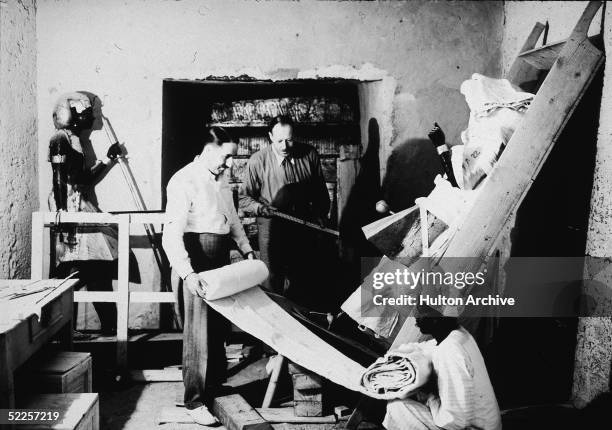 British archaeologists Howard Carter and Arthur Callender carry out the systematic removal of objects from the antechamber of the tomb of Pharaoh...