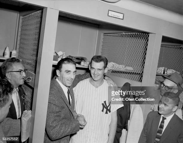 Pitchers Sal Maglie of the Brooklyn Dodgers and Don Larsen of the New York Yankees meet again in the clubhouse at Yankee Stadium after Larsen pitched...
