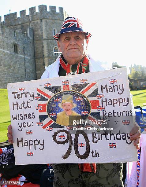 Royal 'super-fan' Terry Hutt holds up a placard after spending the night on a bench outside Windsor Castle in preparation for the Queen's 90th...