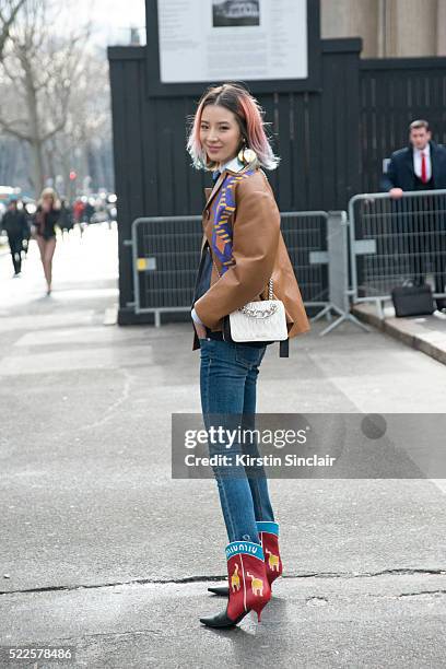 Fashion blogger Irene Kim wears Prada earrings, Miu Miu top, jacket, boots and bag and Rag and Bone jeans on day 9 during Paris Fashion Week...