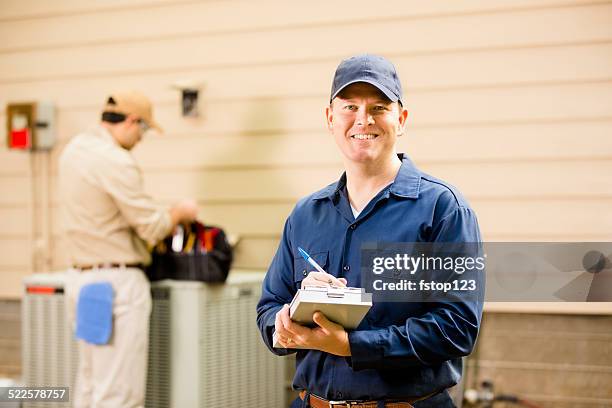 condizionatore d'aria repairmen lavoro su unità principale. operai. - servizio a domicilio foto e immagini stock