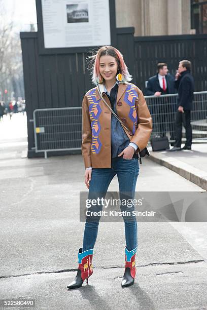 Fashion blogger Irene Kim wears Prada earrings, Miu Miu top, jacket, boots and bag and Rag and Bone jeans on day 9 during Paris Fashion Week...