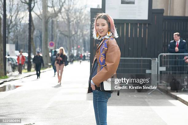 Fashion blogger Irene Kim wears Prada earrings, Miu Miu top, jacket and bag and Rag and Bone jeans on day 9 during Paris Fashion Week Autumn/Winter...