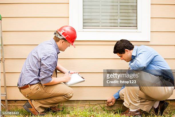 inspectors or blue collar workers examine building wall, foundation. outdoors. - building foundations stock pictures, royalty-free photos & images